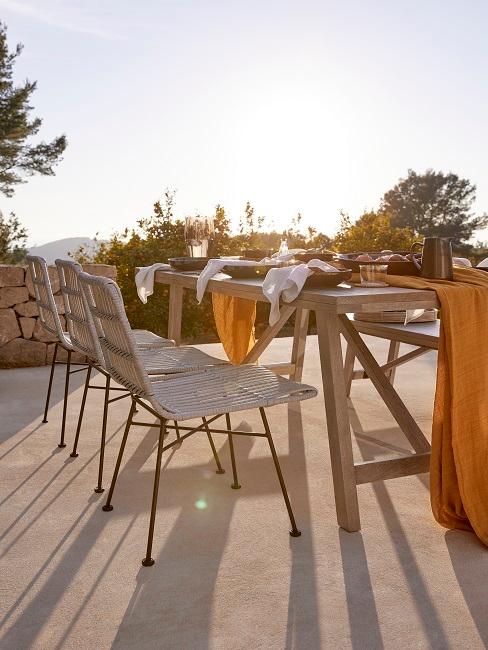 Tuinset Heading Houten tuinset met rotan tuinstoelen bij ondergaande zon