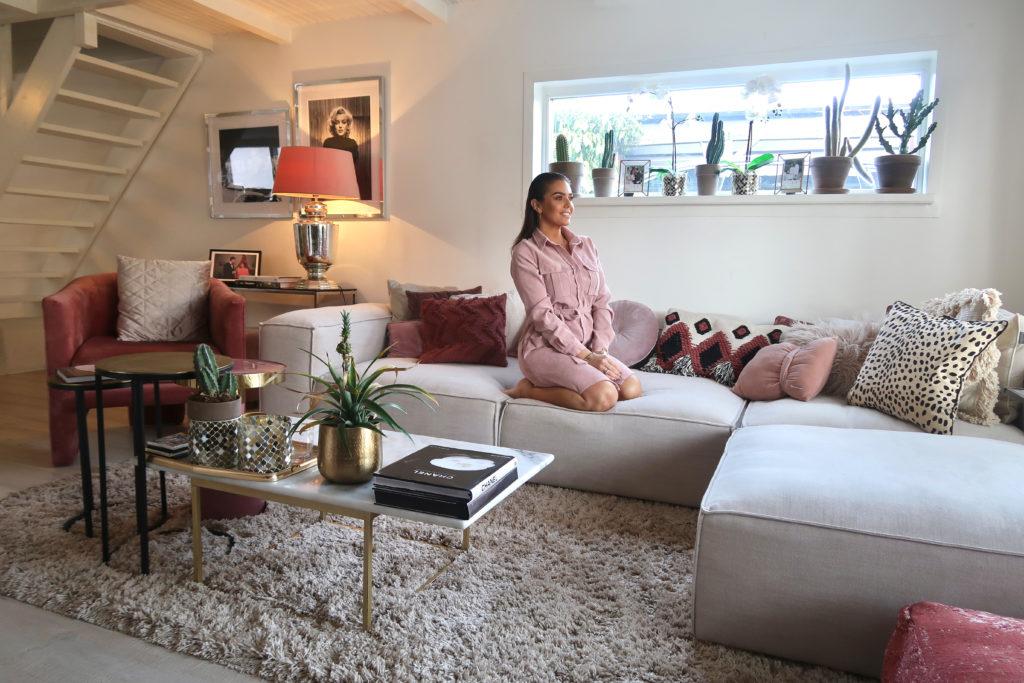 Laura Ponticorvo in haar woonkamer zittend op haar grijze lennon bank