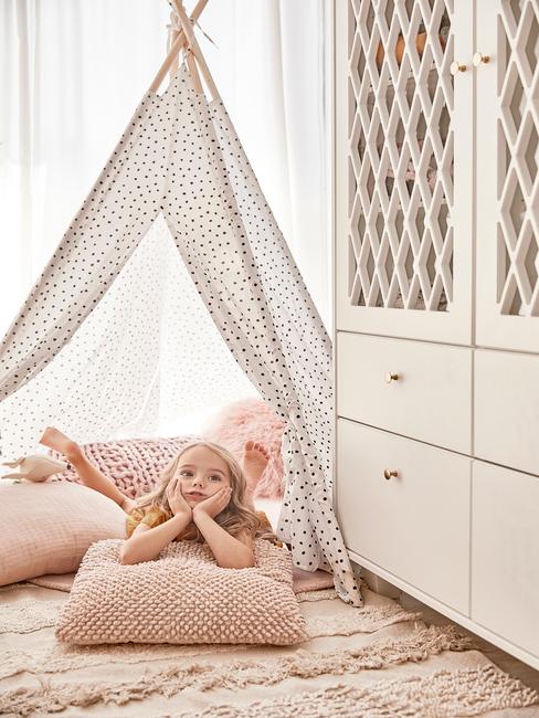 Indeling commode hoofdfoto Kind in kinerkamer met klamboe, roze kussens en witte kast