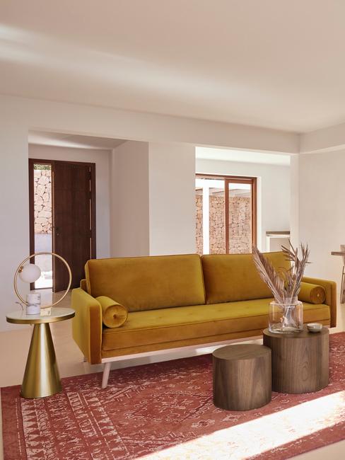 Sofa do salonu Salon w stylu boho z sofą w kolorze ochry i drewnianymi dodatkami