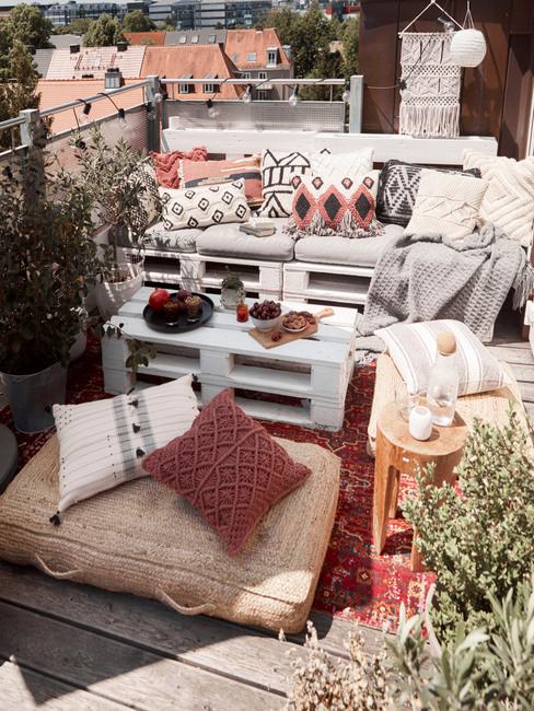Balok z sofa oraz stolikiem ogrodowym wykonane z palet