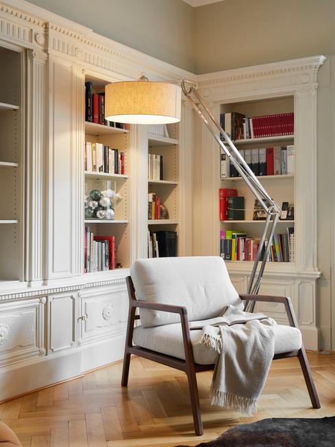 Biblioteczka w salonie z jasnym fotelem