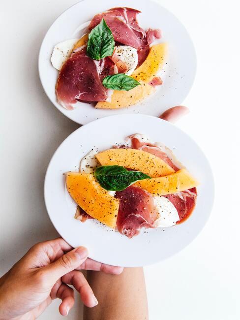 melon z szynka parmeńską na białym talerzu