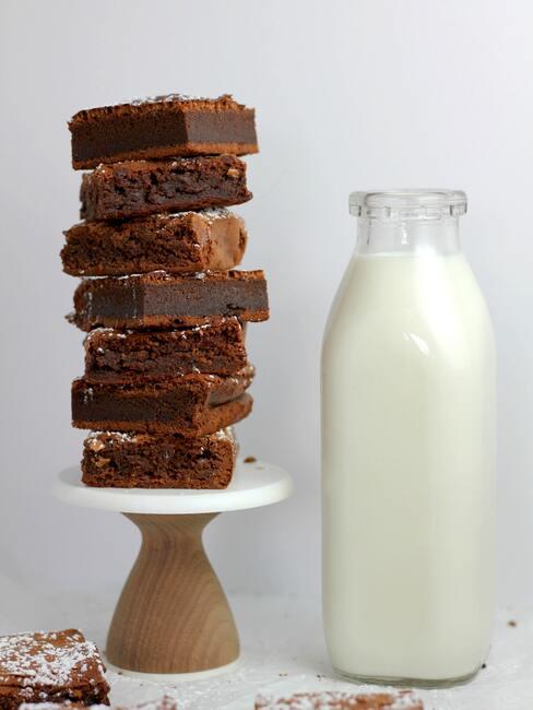 Przepis na brownie Brownie ułożone w stos na paterze, butelka mleka obok