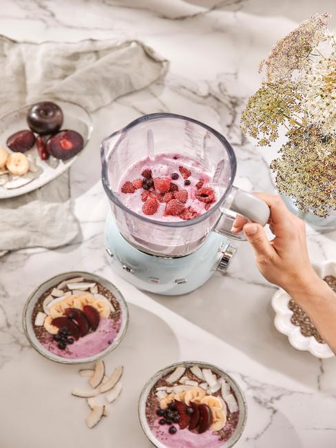 Blender z koktajlem na smoothie bowl oraz dwie białe miseczki