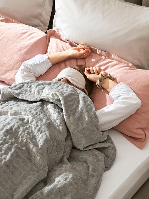 Kobieta śpiąca za maską na oczach pod kołdrą terapeutyczną