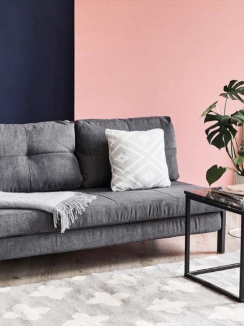 Sofá futón Sofá futón en gris oscuro con pared de fondo rosa y auzl oscuro