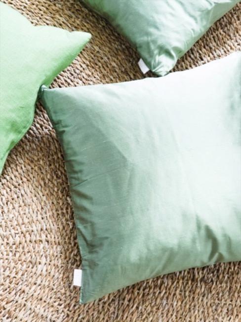 Greenery color Pantone 2017 Cojines en color verde greenery sobre puf de mimbre