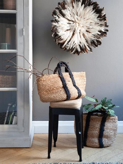 Decoración de paredes del salón Salón con pared gris oscuro, taburete con cesta de mimbre, mueble de madera grisáceo y plantas