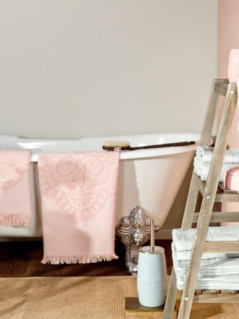 limpiar bañera cuarto de baño con bañera blanca, una escalera y toallas rosas