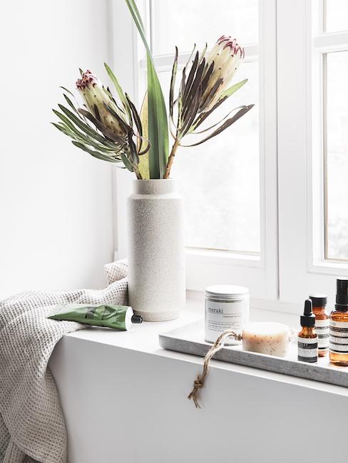 Fensterbank im Bad mit Beautyprodukten von organic Brands und Blumenvase