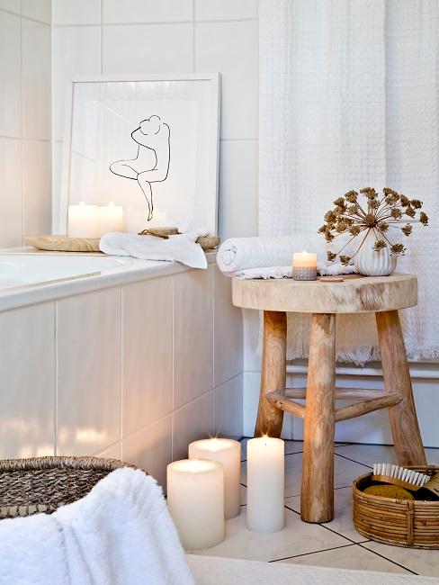 Bad ohne Fenster Badezimmer ohne Fenster mit Badewanne, daneben ein Holzhocker, viele Kerzen und ein Bild im Scandi Stil
