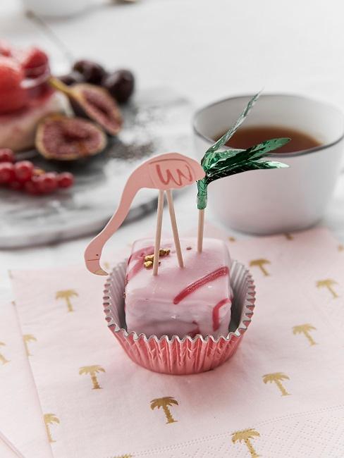 Ein Deko-Flamingo auf einem kleinen Muffin auf dem Tisch