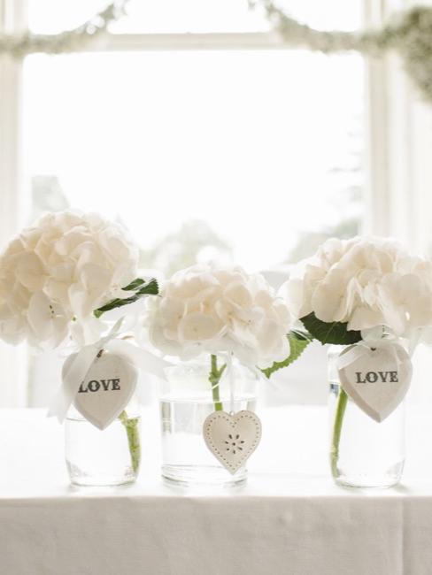 Herzdeko Hochzeit Weiße Hortensien verziert mit Herzdeko in Glasvasen zur Hochzeit