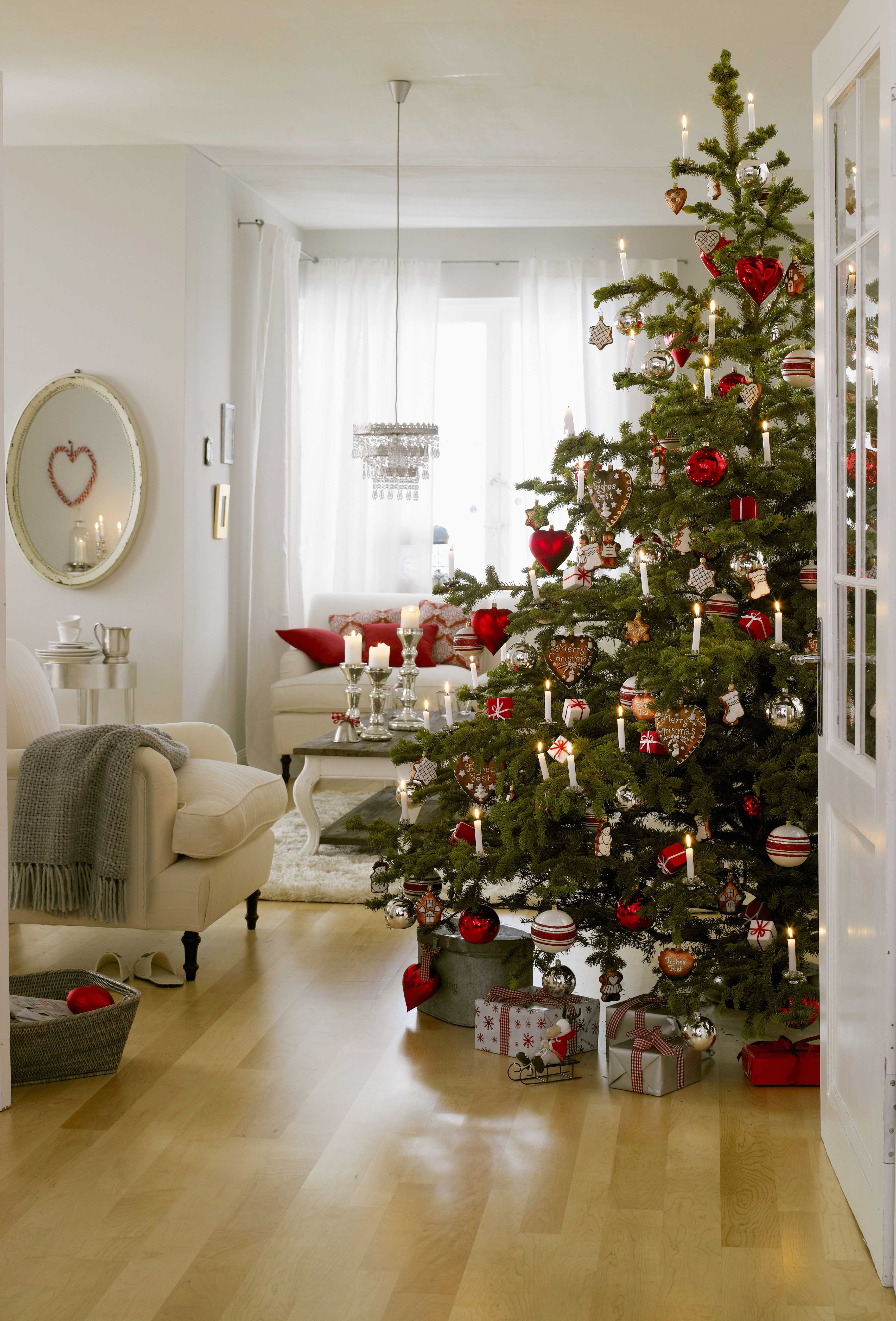 A Christmas tree decorated in red, white, silver and natural shades
