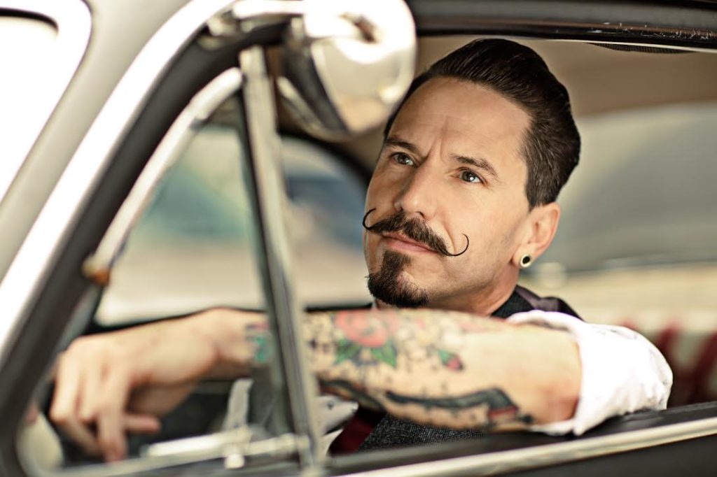 Man with moustaches sitting in car
