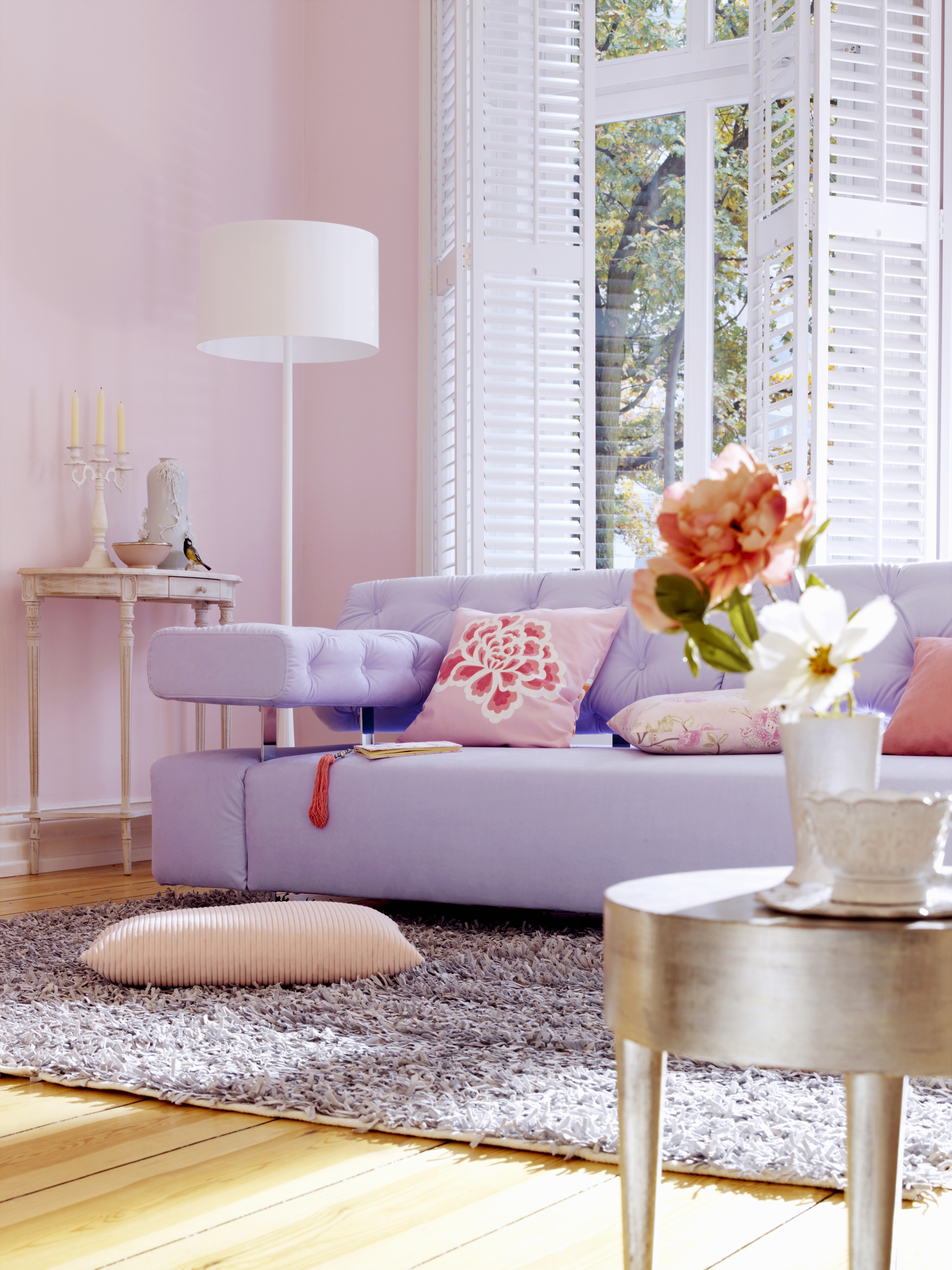Fliederfarbenes Sofa und Beistelltisch mit Blattsilber im Wohnzimmer mit rosa Wänden